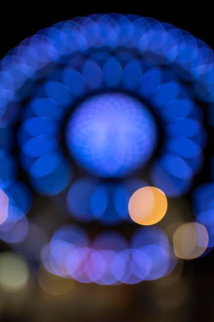 Noria de neón azul borrosa en un carnaval en la noche