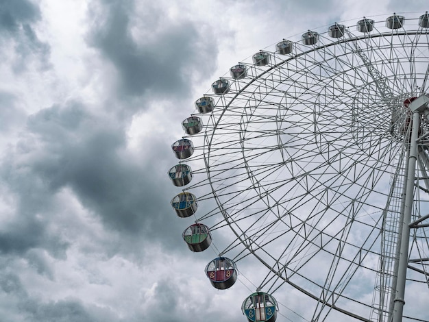 Noria panorámica en el parque de atracciones en el fondo del cielo nublado