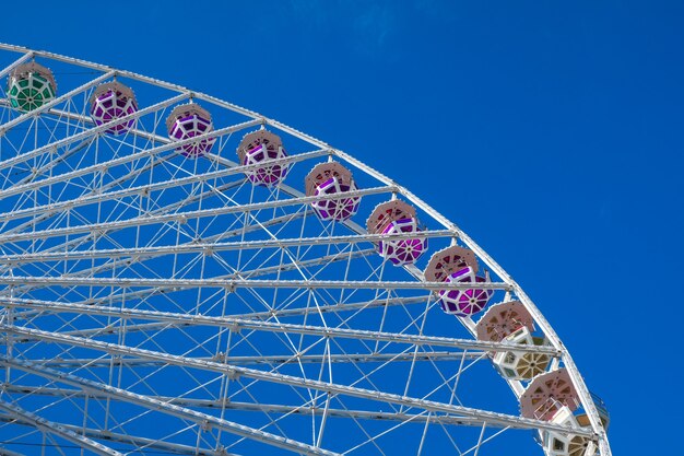 Noria sobre fondo de cielo azul. En el parque de atracciones. El fin de semana