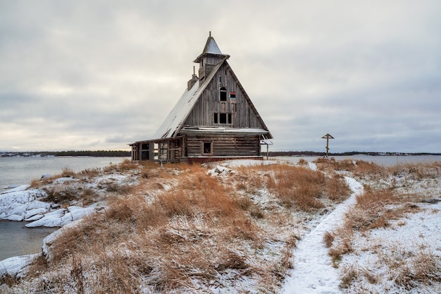 Norte de Rusia. Paisaje nevado de invierno con auténtica casa cinematográfica en la orilla del pueblo ruso Rabocheostrovsk.