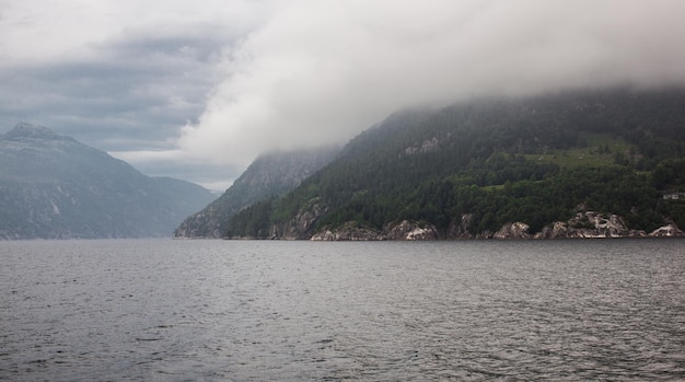 Noruega escandinávia linda paisagem na margem do lago no meio das montanhas de pedra nuvens de chuva