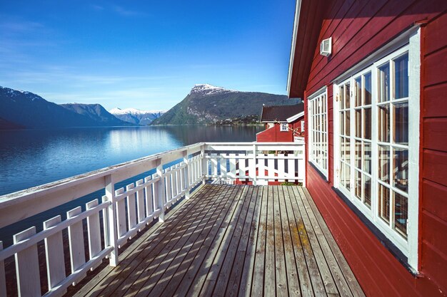 El noruego con casa adosada con montañas y una cascada en el fondo, noruega