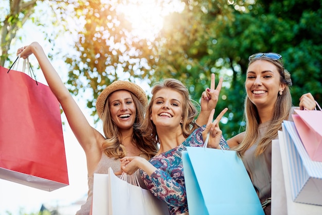 Nos encanta ir de compras Retrato recortado de tres jóvenes amigas de compras en el centro de la ciudad