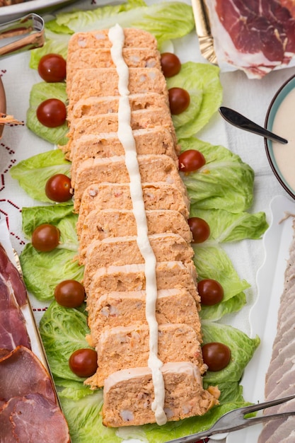 Nos enfocamos en un pastel de pescado color salmón una mesa llena de comida