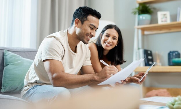 Nos estaba yendo tan bien con nuestras finanzas. Foto de una pareja joven sentada en la sala de estar de su casa y calculando sus finanzas.