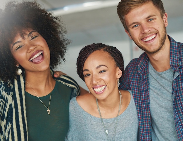 Nos gusta mantener las cosas vibrantes y divertidas en el trabajo Retrato de un grupo de jóvenes colegas felices y exitosos en una oficina moderna