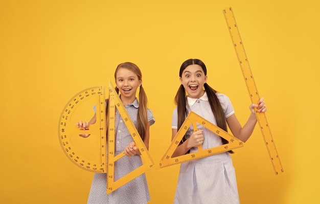 Nos reunimos para aprender Niñas adolescentes felices sostienen herramientas geométricas Lección de geometría Educación escolar Día del conocimiento 1 de septiembre Aprender y crecer juntos