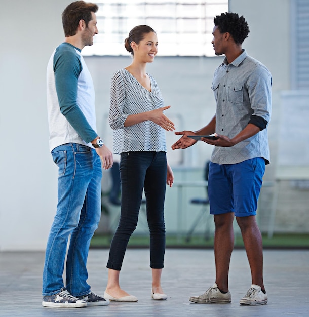 Nossas equipes querem manter a realidade Três colegas de trabalho criativos vestidos casualmente se encontrando e cumprimentando uns aos outros