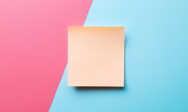 Foto nota adhesiva amarilla en blanco sobre un fondo rosa y azul