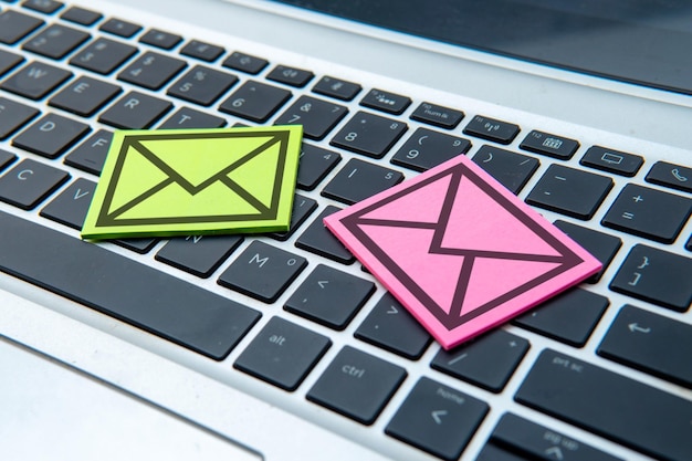 La nota adhesiva con un contorno negro de un sobre en un teclado de portátil Concepto de correo electrónico y comunicación