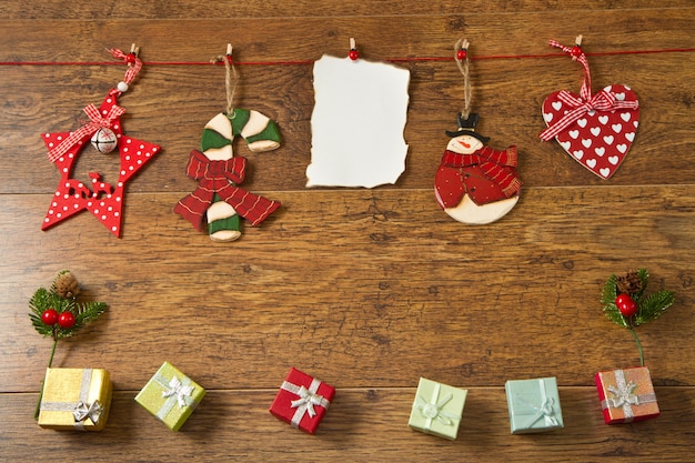 Nota en blanco con la decoración de Navidad sobre fondo de madera