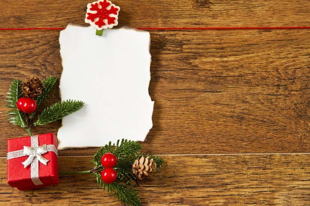 Nota en blanco con la decoración de Navidad sobre fondo de madera