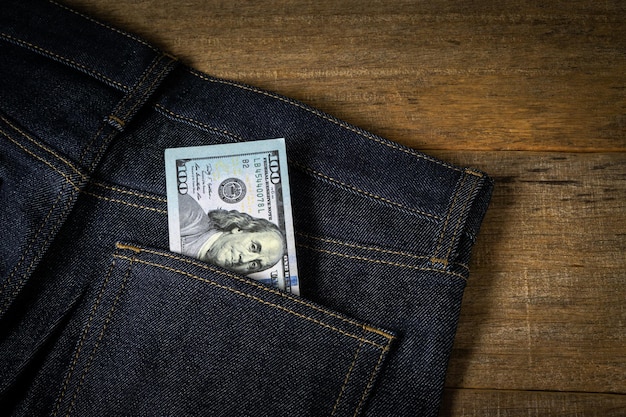 Nota de dólar no bolso da calça jeans.