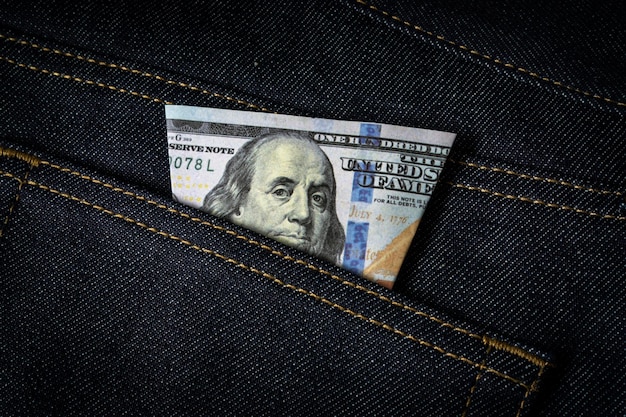 Nota de dólar no bolso da calça jeans.