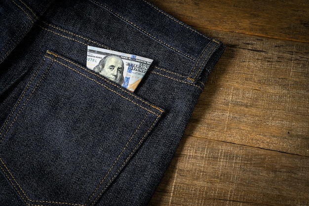 Nota de dólar no bolso da calça jeans.