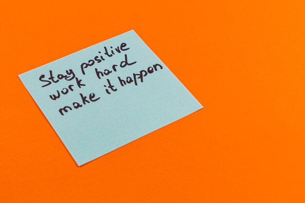 Nota de motivación en fondo naranja que fomenta la positividad y el trabajo duro