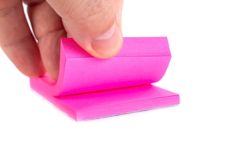 Foto nota de papel de colores con la mano de un chico, objeto