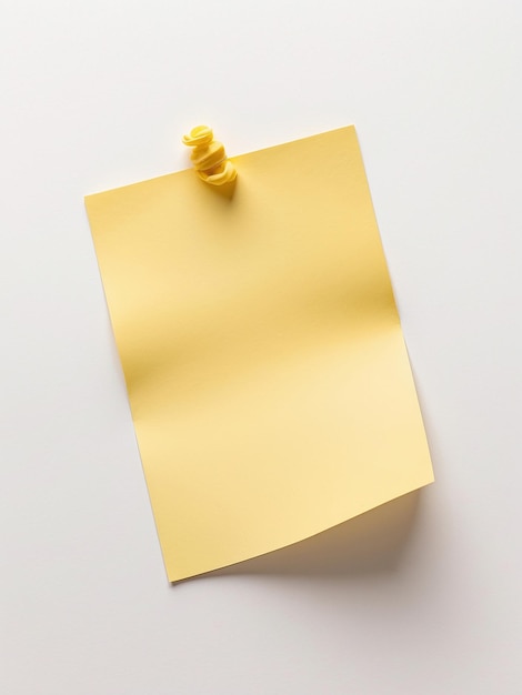 Nota pegajosa de color amarillo brillante en una superficie blanca sencilla