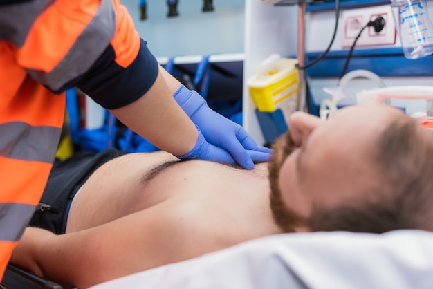 Notarzt reanimiert einen Patienten im Krankenwagen. CPR-Reanimation.