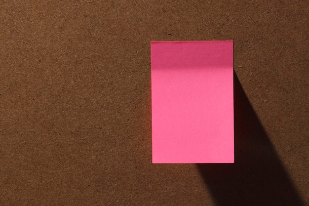 Notas adesivas quadradas rosa para escritório em quadro de cortiça com sombra dura