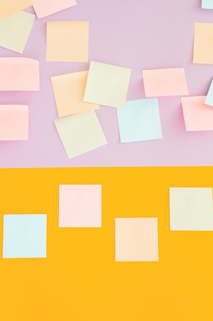Notas adhesivas de colores sobre fondo amarillo y violeta