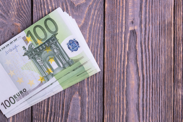 Notas de dinheiro do Euro em um fundo escuro de madeira.