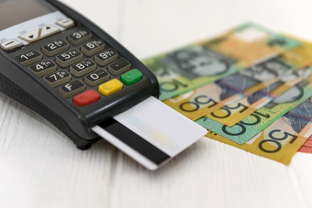 Notas de dólar australiano com terminal e cartão de crédito
