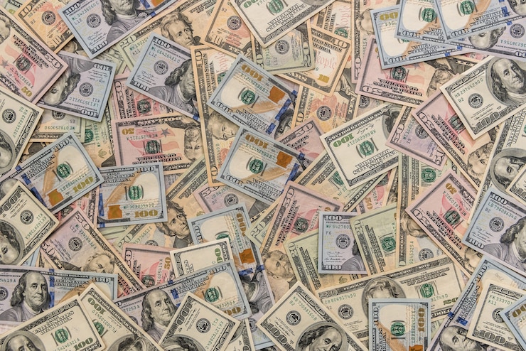Foto notas de dólar dispersas na mesa de madeira close-up