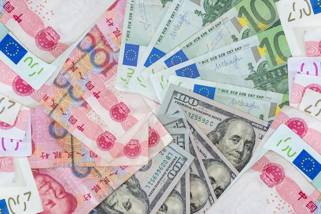 Notas de dólar dos Estados Unidos e de euro yuan como fundo