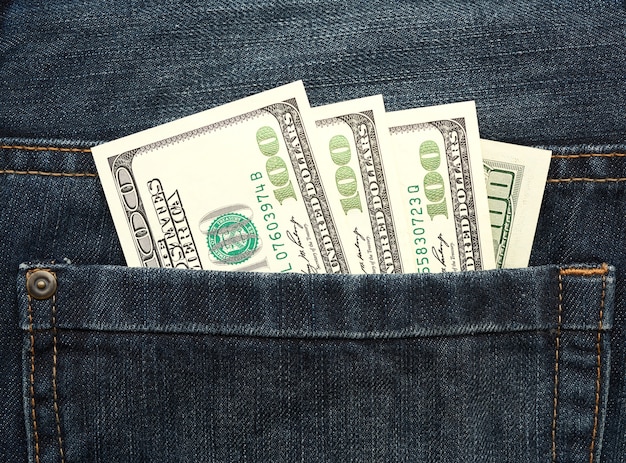 Notas de dólar dos Estados Unidos no bolso traseiro da calça jeans