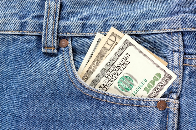 Notas de dólar dos EUA no bolso frontal direito do jeans azul Conceito de economizar dinheiro ou despesas de bolso