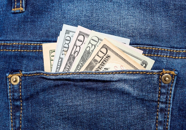 Notas de dólar no bolso traseiro da calça jeans