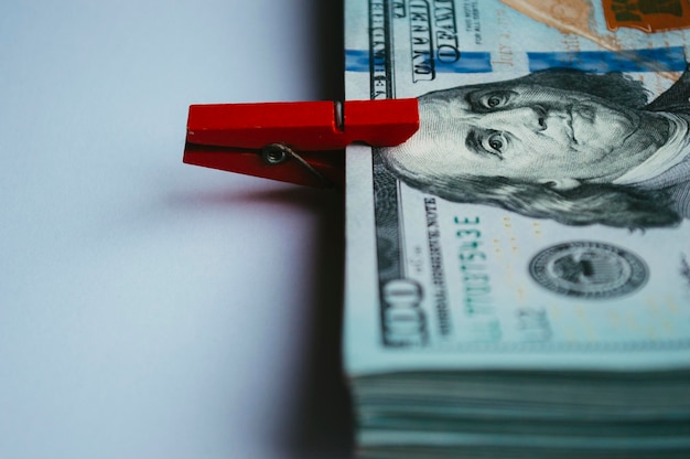 Notas de dólar seladas com um prendedor de roupa vermelho