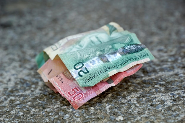 notas de dólares canadenses em fundo de concreto