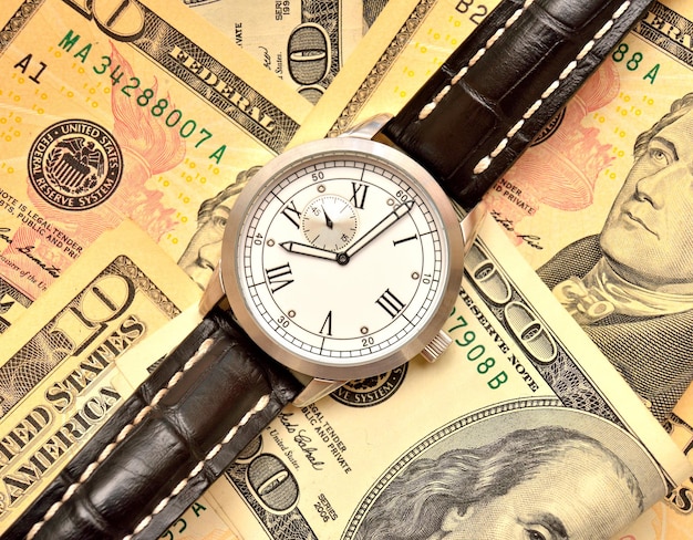 Notas de dólares e relógio