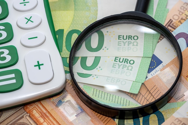 Notas de euro com negócios de conceito de finanças de lupa