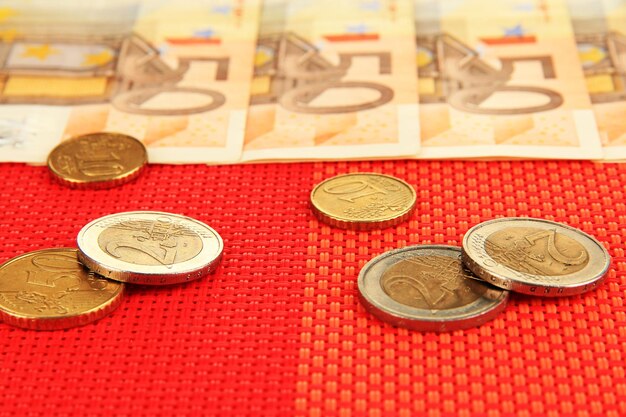 Notas de euro e centavos de euro em fundo vermelho