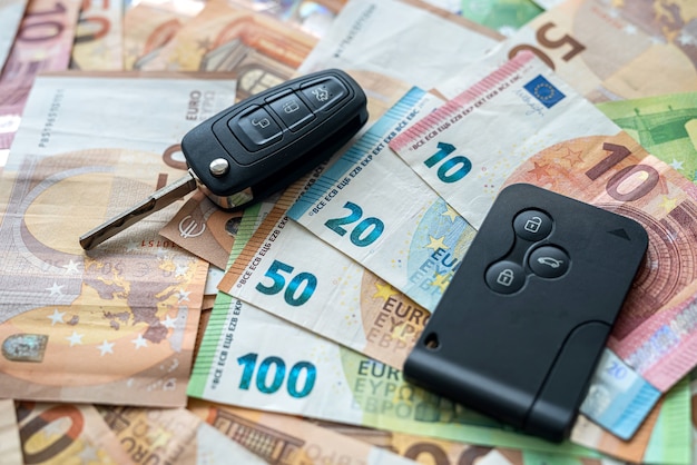 Notas de euro e uma chave de carro. seguro de investimento em automóveis. conceito de venda ou aluguel