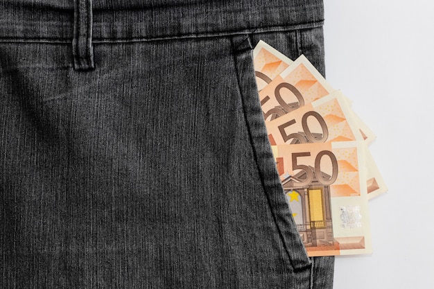 Notas de euro no bolso da calça jeans, fundo preto