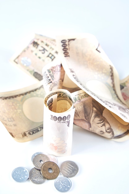 Notas de ienes japoneses e moeda de iene japonês em fundo branco