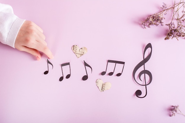 Notas de papel de clave musical de papel e mão infantil em educação musical rosa Vista superior