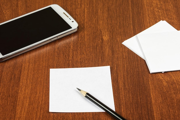 Notas de um smartphone e um lápis estão sobre a mesa