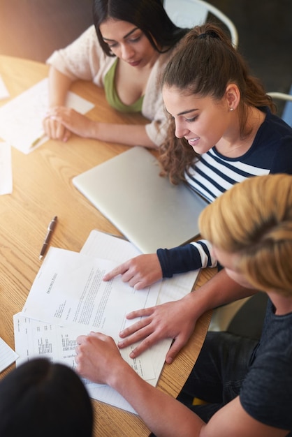 Notas estudantes e mulheres na mesa para estudar pesquisa e sessão na cafeteria trabalhos de grupo de estudo e documentos para aprender juntos na faculdade para progresso educacional e conhecimento para exames
