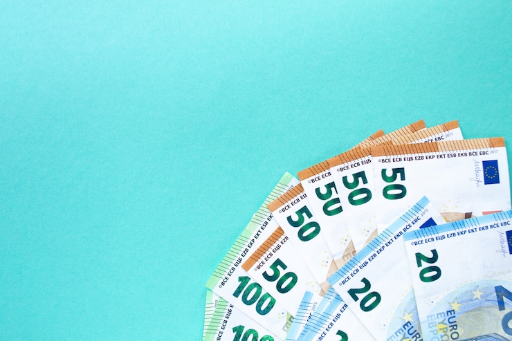 Foto notas nas denominações de 100, 50 e 20 euros, com o canto esquerdo. sobre um fundo azul o conceito de dinheiro e finanças. com lugar para texto.