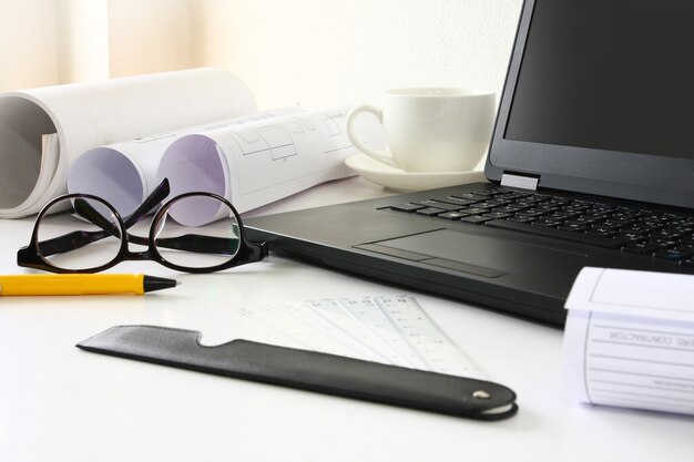 Notebook-Arbeitsgerät hat eine Papierrolle auf dem Schreibtisch.