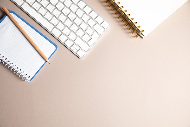 Notebook, caneta e teclado na mesa