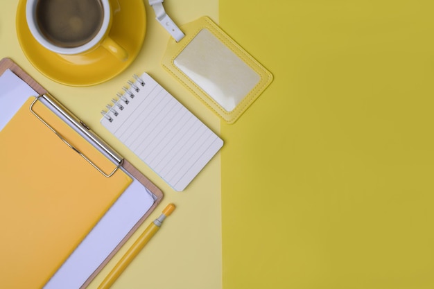 Notebook-Kaffeetasse und Klemmbrett auf gelbem Hintergrund
