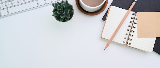 Notebook, Kaffeetasse und Tastatur auf dem Tisch