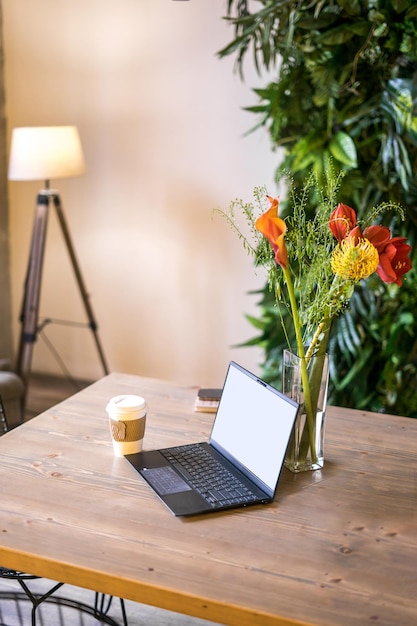 Notebook mit leerem Bildschirm auf dem Tisch im Wohnzimmer.