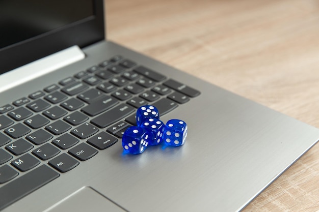 Notebook mit Würfeln auf einem Holztisch Online-Gaming-Casino